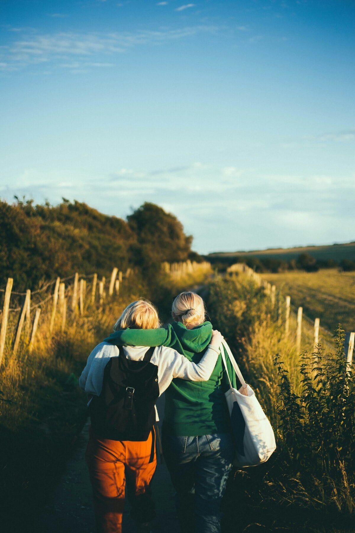 vriendschap twee vriendinnen met de armen over elkaar op een wandelpad