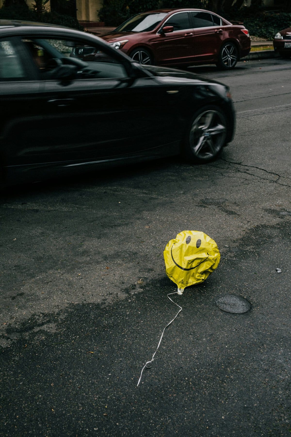 ballon met een smiley op de weg met auto