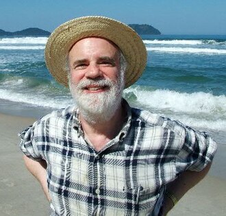 Saul Kripke op het strand met een hoed op