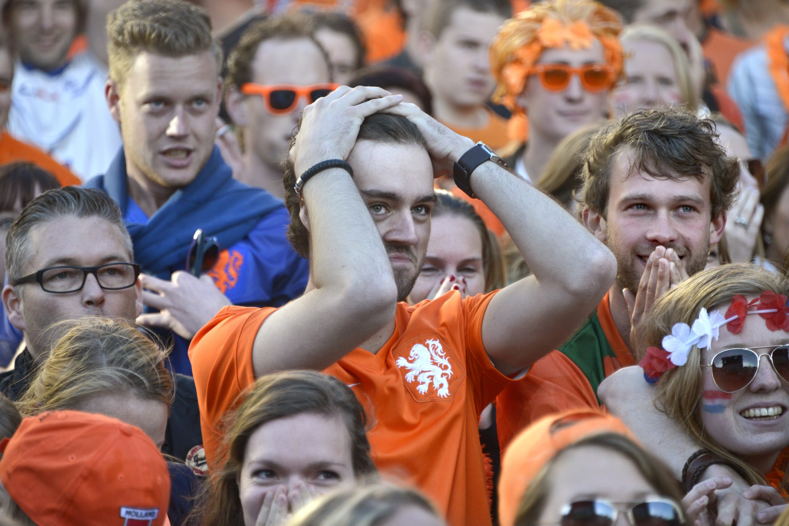 Oranjefans volgen op straat een wedstrijd van het Nederlands elftal