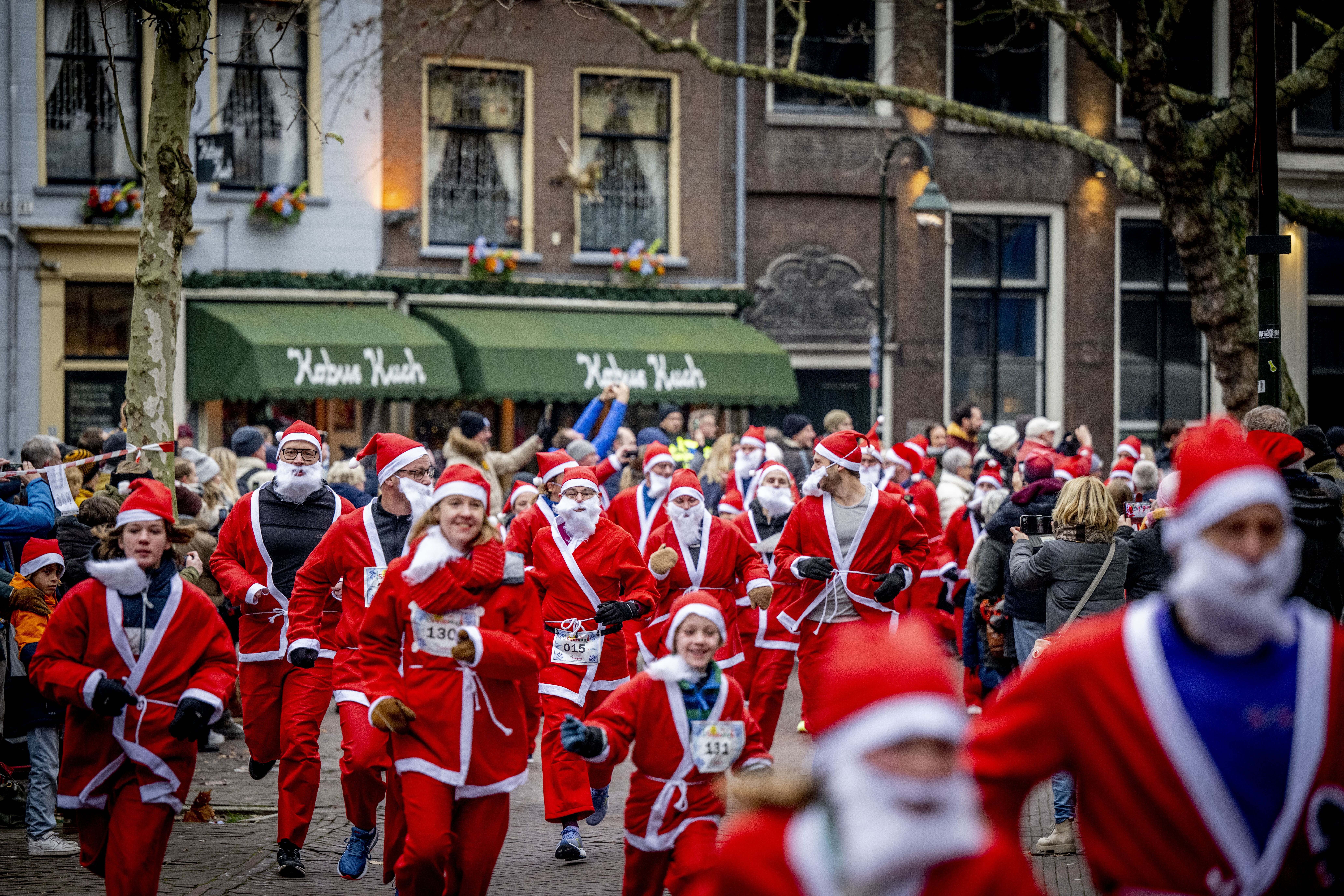 Santa Run hardlopers in kerstmanpak lopen voor het goede doel in Delft