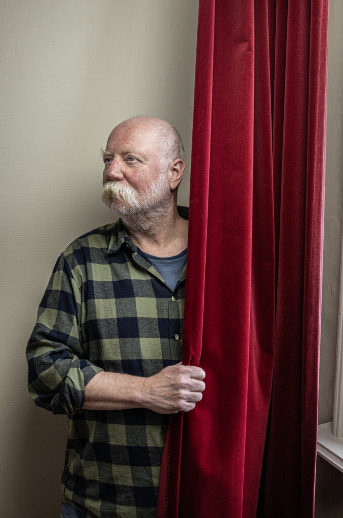 dichter Piet Gerbrandy achter een gordijn