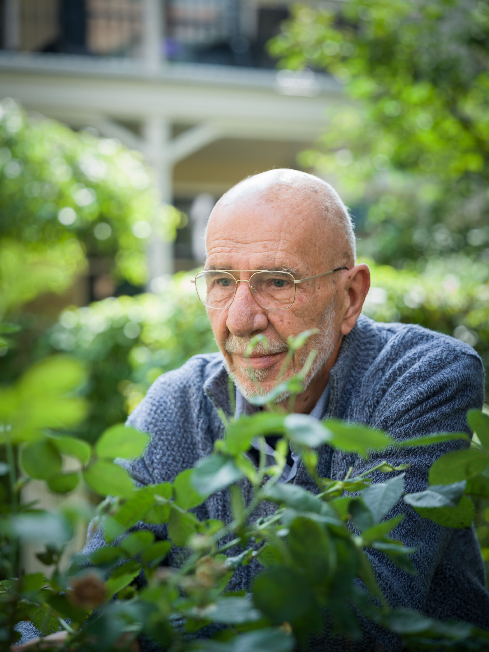 natuurfilosoof Matthijs Schouten in de tuin achter een struik