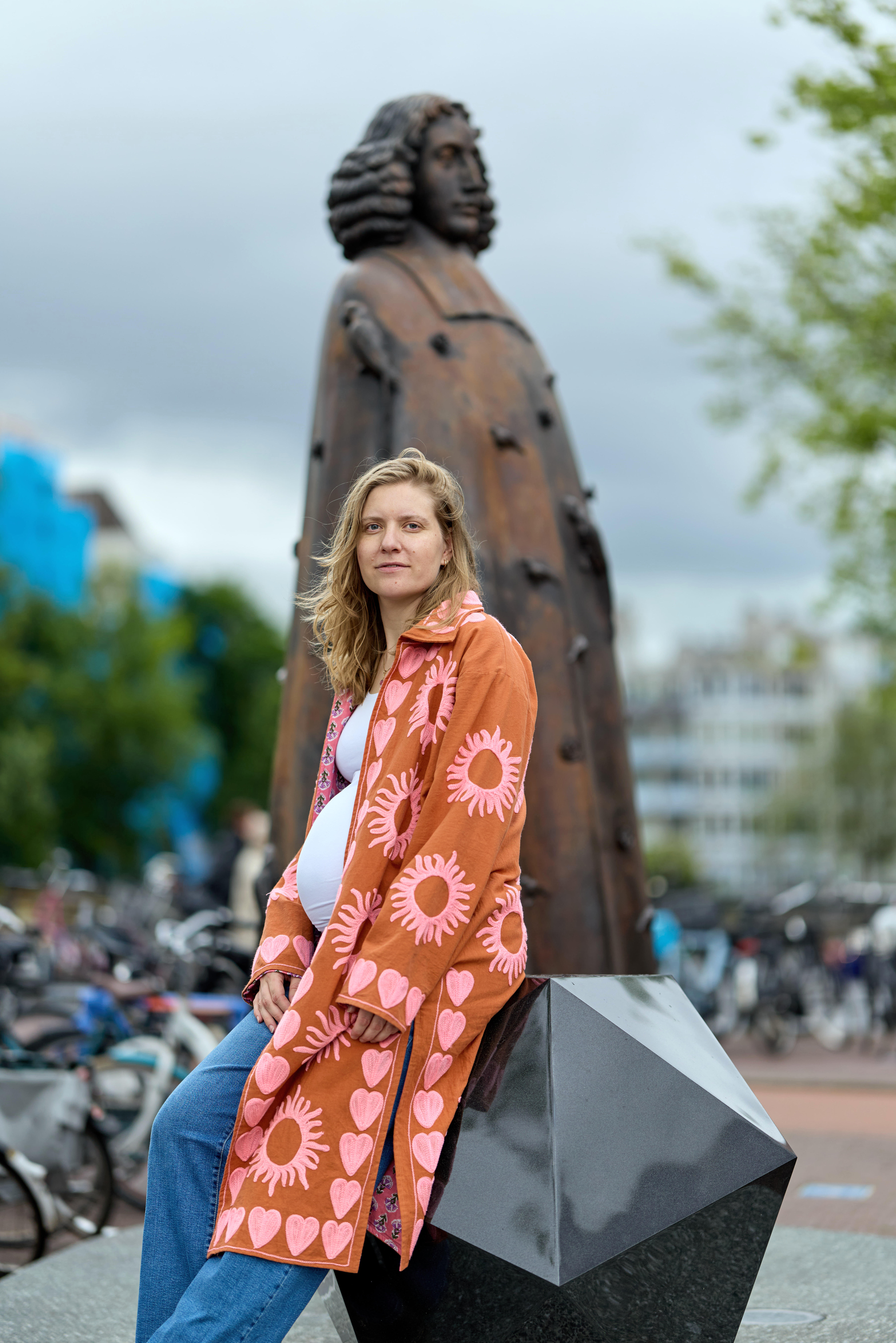filosoof en ambtenaar Laura Keulartz bij het standbeeld van Spinoza in Amsterdam